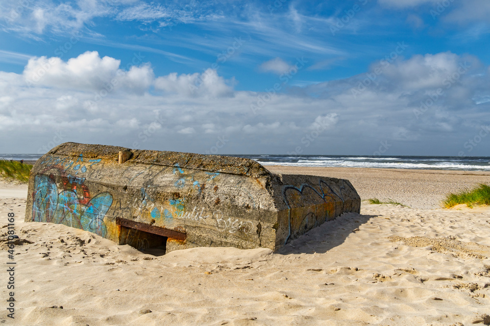 Word War II bunker stained by graffiti and submerged in sand on Nymindegab Beach. South West Jutland, Denmark, Europe