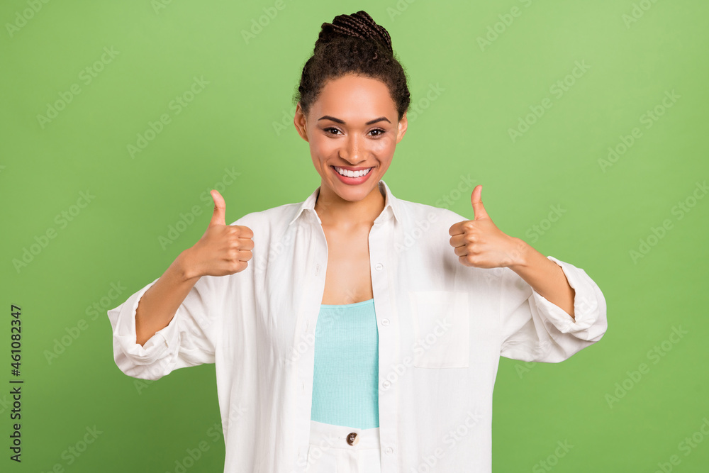 Photo portrait woman with bun hairstyle showing thumb-up like isolated pastel green color background Photo portrait woman with bun hairstyle showing thumb-up like isolated pastel green color background