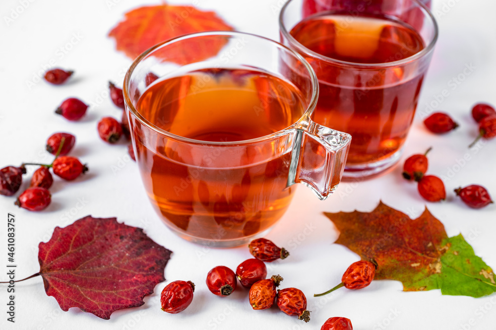 Cups of rosehip tea, dried fruit and autumn leaf on white background. Cups of rosehip tea, dried fruit and autumn leaf on white background.