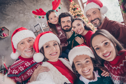 Photo portrait big family taking selfie smiling tjgether wearing festive xmas outfit headwear in decorated apartment