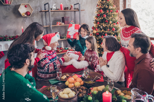 Photo portrait small children receive present box on christmas from santa claus sitting at table with full family