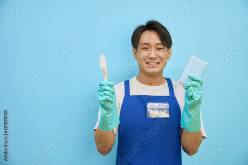 掃除用具をもってほほ笑む 日本人男性