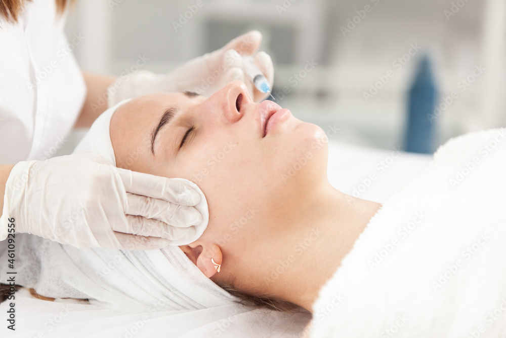 Cosmetologist does injections for lips augmentation and anti wrinkle of beautiful woman. Women's cosmetology in the beauty salon. Cosmetologist does injections for lips augmentation and anti wrinkle of beautiful woman. Women's cosmetology in the beauty salon.