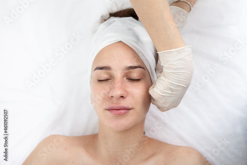Cosmetic procedures. Feminine beautiful face. Doctor's hands. Beauty salon. Top view