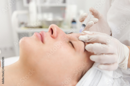 Cosmetologist does injections for anti wrinkle of beautiful woman. Women's cosmetology in beauty salon