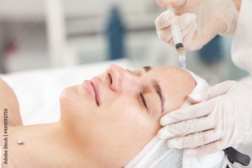 Cosmetologist does injections for anti wrinkle of beautiful woman. Women's cosmetology in beauty salon Cosmetologist does injections for anti wrinkle of beautiful woman. Women's cosmetology in beauty salon