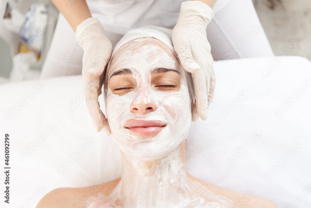 Skin care. Beautiful woman in rejuvenating mask with closed eyes in beauty salon