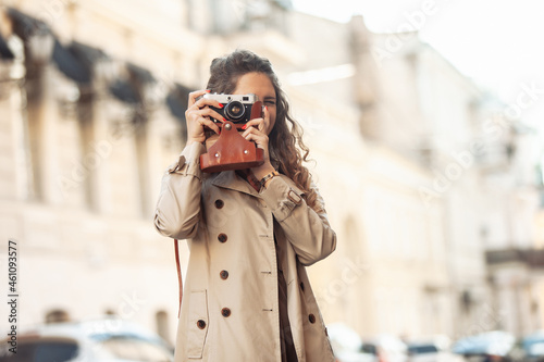 Young woman tourist with retro camera in a European street