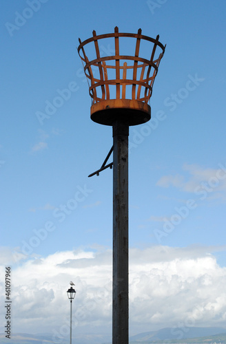 Traditional Iron Beacon on Post against Blue Sky