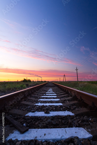 Railway in the steppe . photo right after sunset road leading to the distance