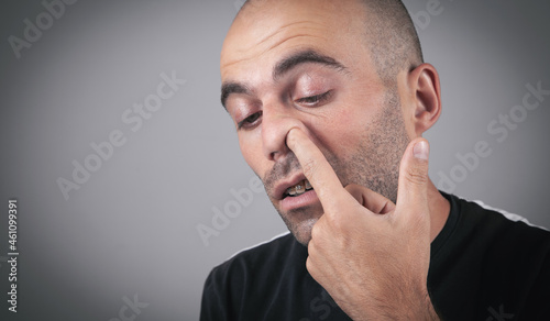 Young man with finger in his nose.