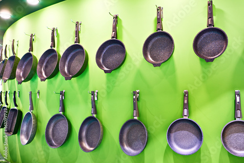 Kitchenware frying pans on wall in store