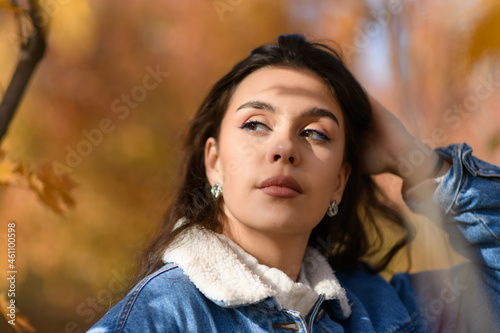 Portrait of young woman walking outdoors in autumn park