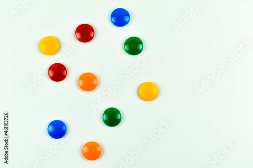 Kolorowe, plastikowe magnesy na kolorowych kartkach papieru.