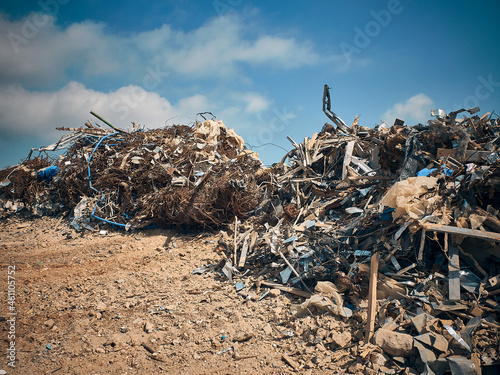 Metal reinforcement rods, lumber and other different kinds of construction debris piled. Construction garbage dump.