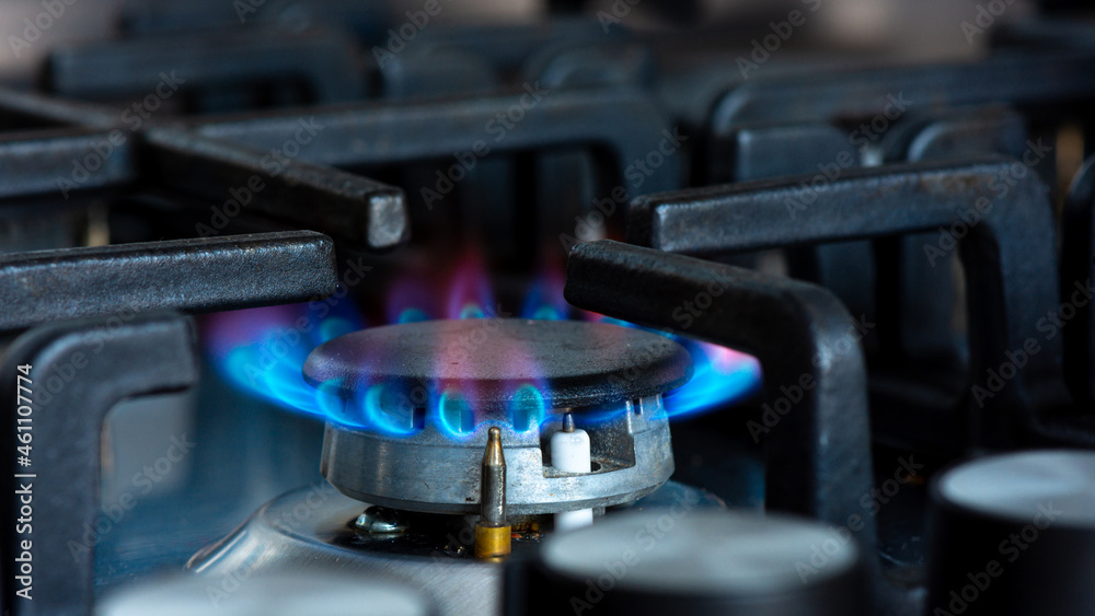 Gaz brûlant avec des flammes bleues sur le brûleur d'une cuisinière à gaz. Concept d'empreinte carbone et de prix du gaz naturel sur le marché - obrazy, fototapety, plakaty 