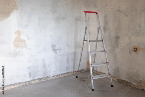 Slika na platnu Building stepladder stands in empty room