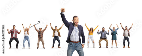 Cheerful young man gesturing happiness and other people behind raising arms photo