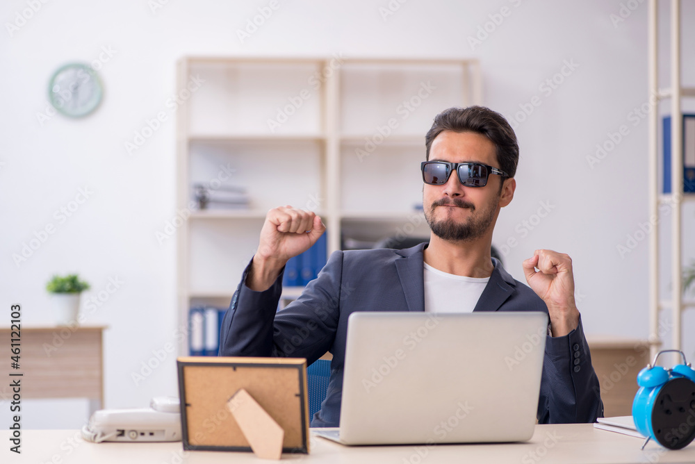 Young handsome employee in time management concept Young handsome employee in time management concept
