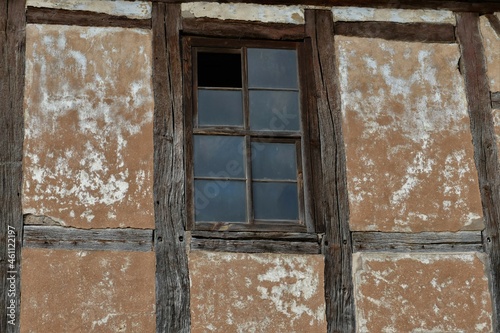 Altes Fenster in brauner verfallener Fachwerkfassade