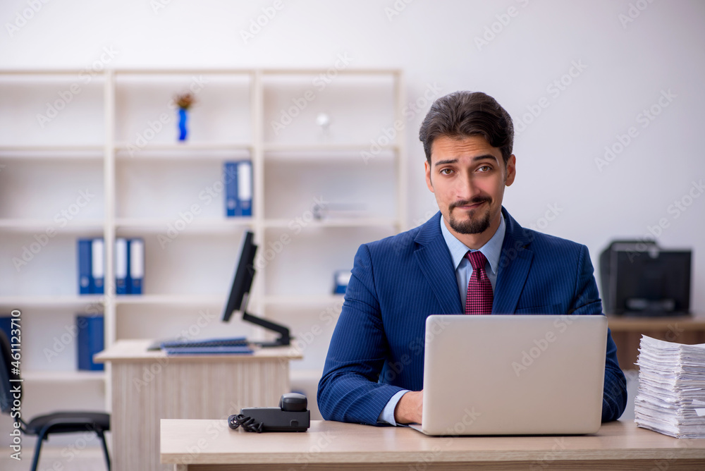 Young businessman employee and too much work in the office Young businessman employee and too much work in the office