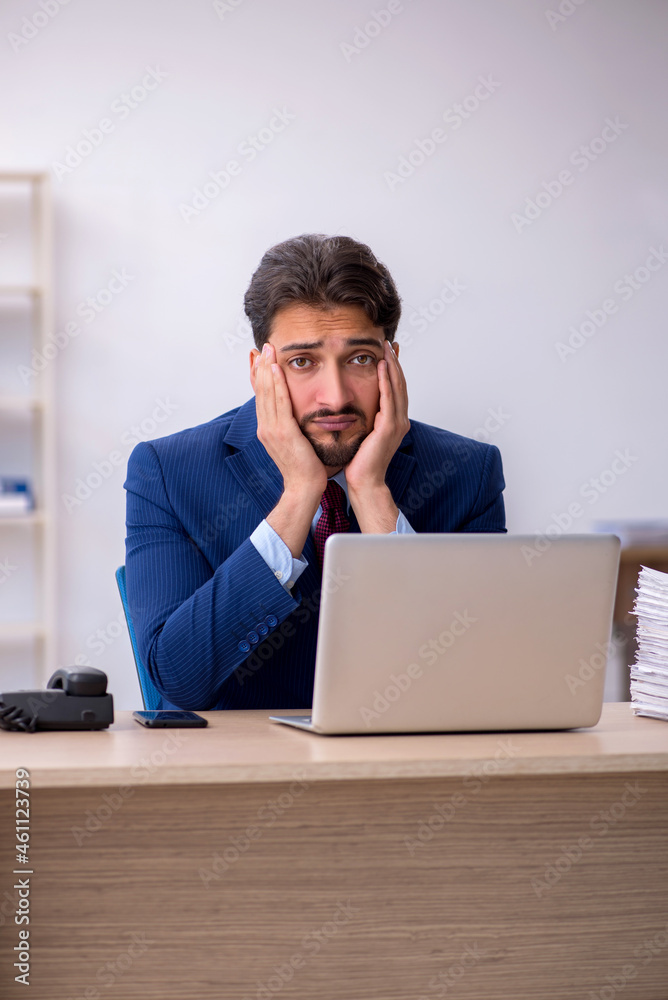 Young businessman employee and too much work in the office Young businessman employee and too much work in the office
