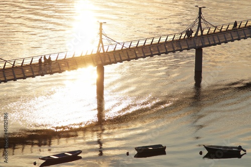 Pier and boats on the Vistula River in Plock in the yellow rays of the setting sun