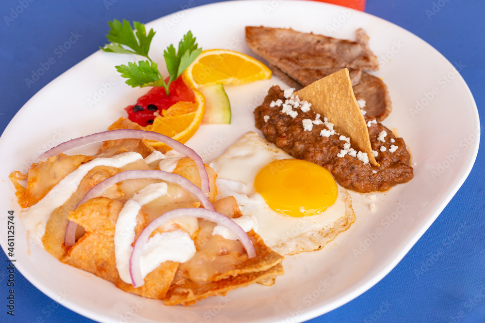 Huevo estrellado con frijoles refritos chilaquiles y fruta Huevo estrellado con frijoles refritos chilaquiles y fruta