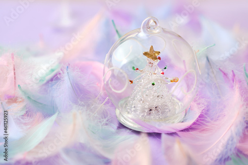 glass Christmas decoration ball against purple background