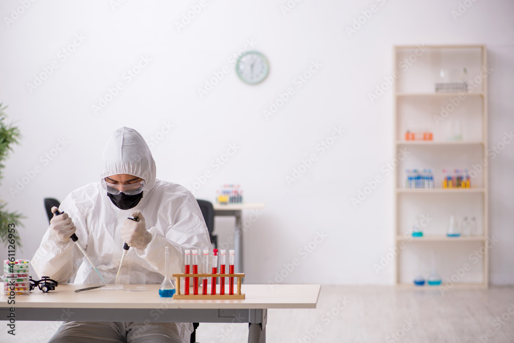 Young male chemist in drugs synthesis concept Young male chemist in drugs synthesis concept