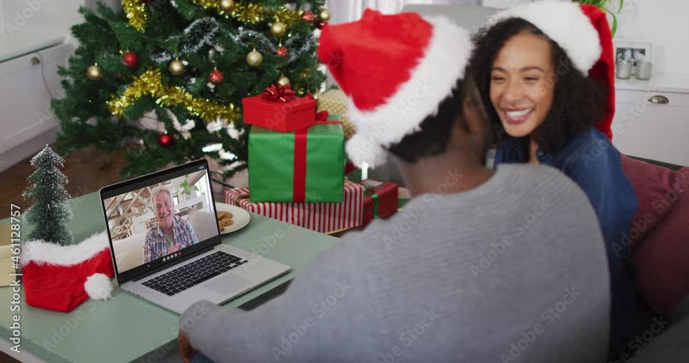 African american couple wearing santa hats having a videocall on laptop at home during christmas African american couple wearing santa hats having a videocall on laptop at home during christmas