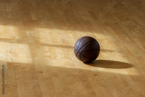Basketball on hardwood court floor with natural lighting. Horizontal sport poster, greeting cards, headers, website and app © Augustas Cetkauskas