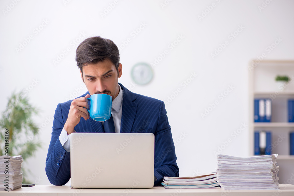 Young male employee drinking coffee during break Young male employee drinking coffee during break