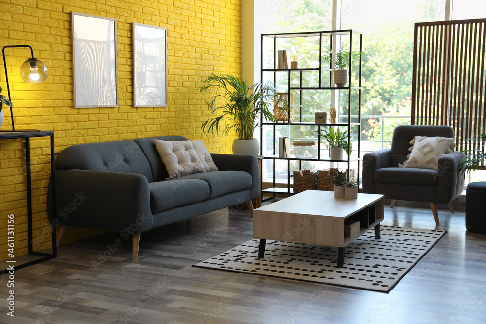 Comfortable grey sofa and armchair in room. Interior design