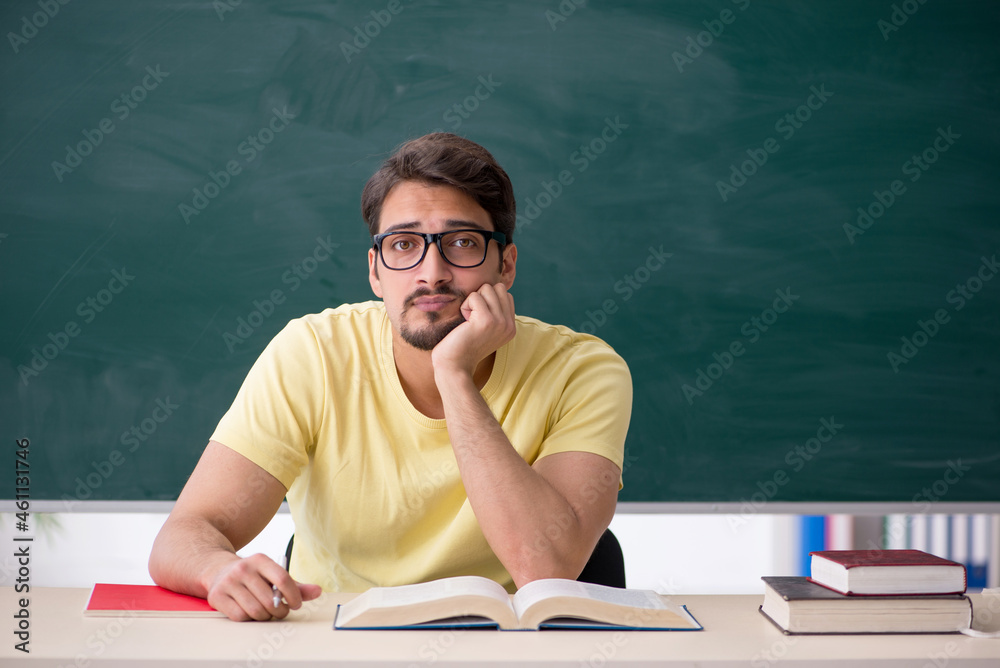 Young male student in front of blackboard Young male student in front of blackboard