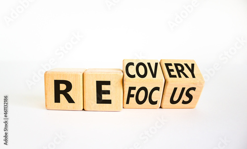 Refocus and recovery symbol. Businessman turned cubes and changed the word 'refocus' to 'recovery'. Beautiful white table, white background. Business refocus and recovery concept. Copy space. photo