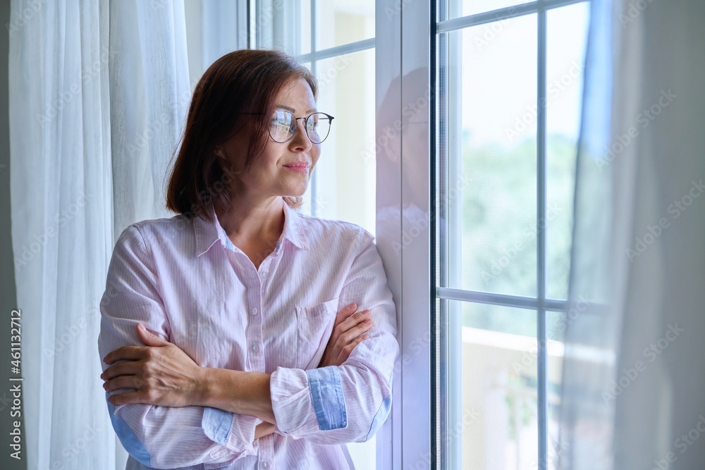 Portrait of a mature confident woman looking out the window Portrait of a mature confident woman looking out the window