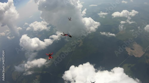 Formation skydiving. A team of skydivers is flying in the amazing cloudy sky.
