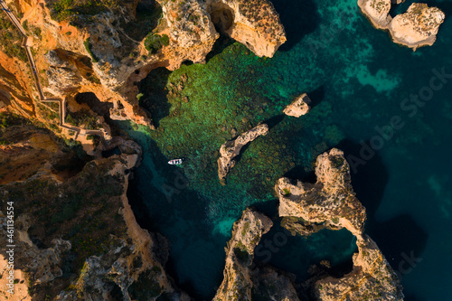 Ponta da Piedade, most famous touristic attractions of Portugal. Aerial view of Atlantic Ocean coast with cliff rocks and tourist boat in Algarve