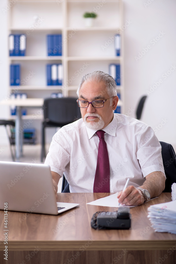 Obraz premium Old male employee and too much work in the office