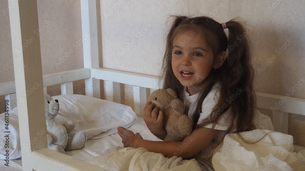 little cute girl is going to go to bed. indulges in, does not want to sleep. naughty. Cute little girl sleeping with teddy bear in bed little cute girl is going to go to bed. indulges in, does not want to sleep. naughty. Cute little girl sleeping with teddy bear in bed