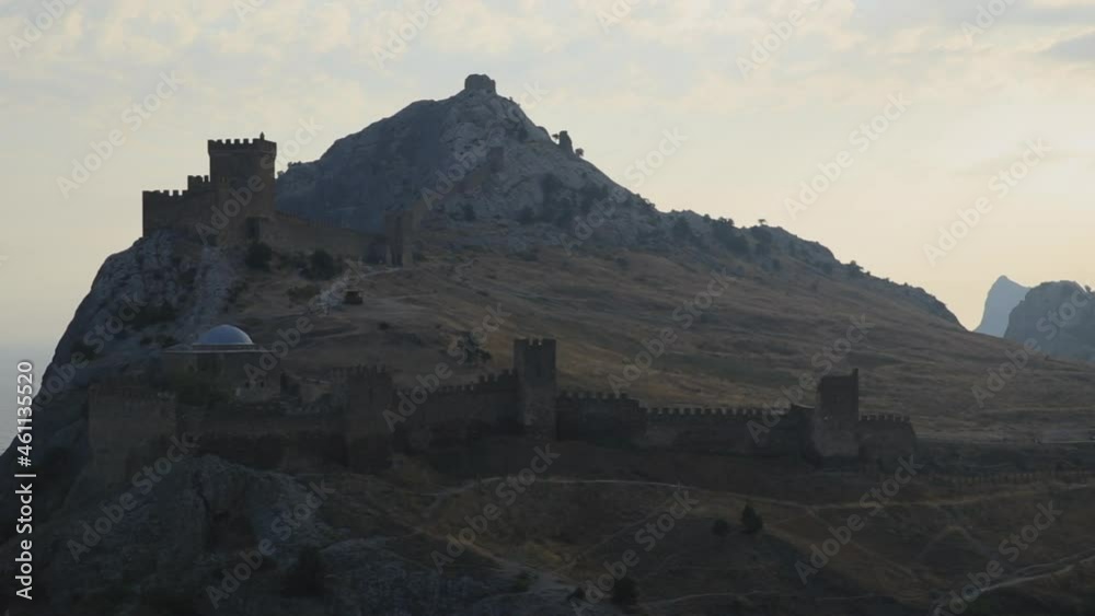 Panorama of ancient Genoese fortress in Sudak town. Historic architectural landmark at sunset. Crimea. Panorama of ancient Genoese fortress in Sudak town. Historic architectural landmark at sunset. Crimea.