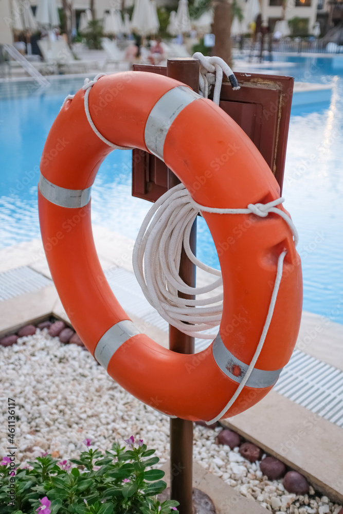 Red lifebuoy and ropes to save lives when drowning people near the pool.