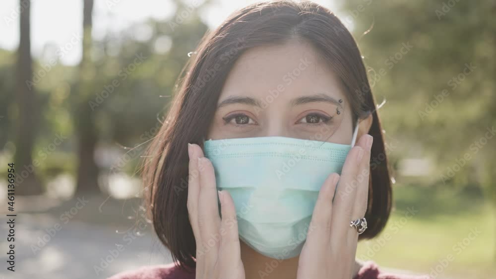 Close-up portrait of nice-looking multi-race brunette beautiful elegant young woman putting on mask for coronavirus protection. Concept of health and safety life COVID-19 protection. Female portraits Close-up portrait of nice-looking multi-race brunette beautiful elegant young woman putting on mask for coronavirus protection. Concept of health and safety life COVID-19 protection. Female portraits