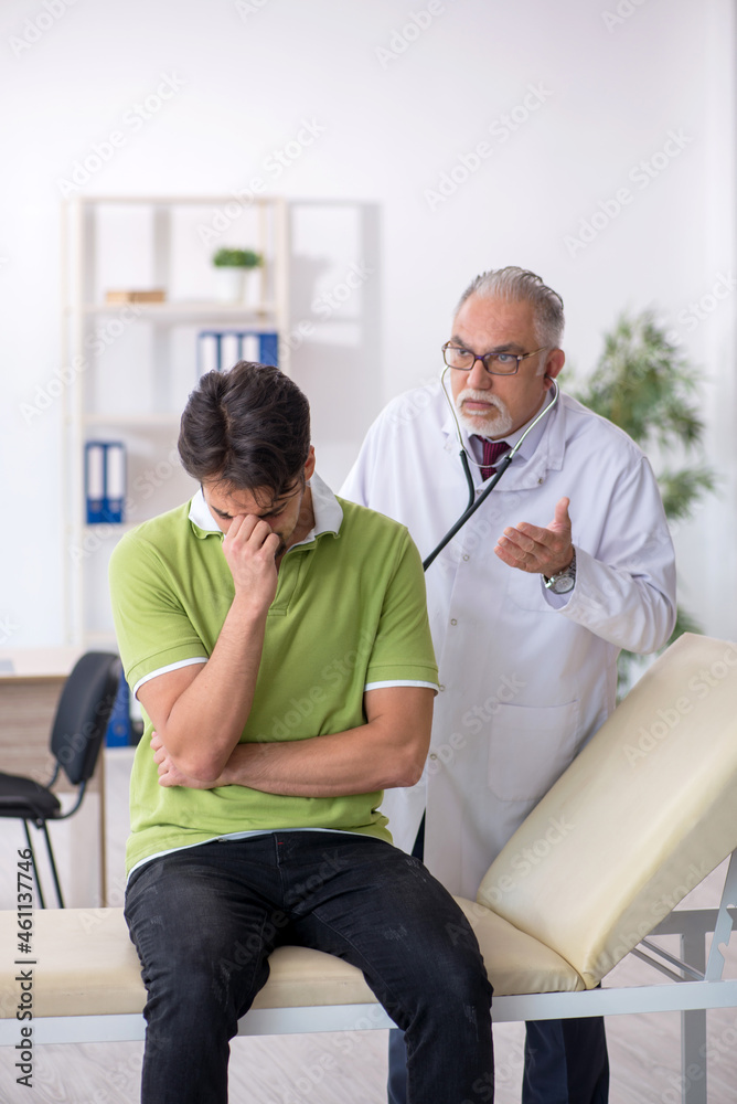 Young male patient visiting old male doctor Young male patient visiting old male doctor