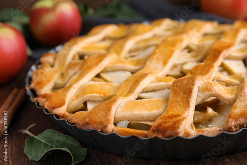 Delicious traditional apple pie on wooden table, closeup