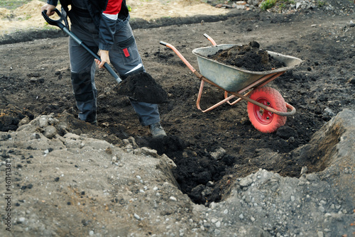 Working with garden tools, shovel and wheelbarrow on the site of a country house Fototapet