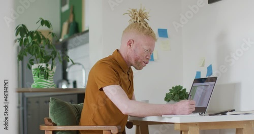 Albino african american man with dreadlocks making video call on the laptop photo