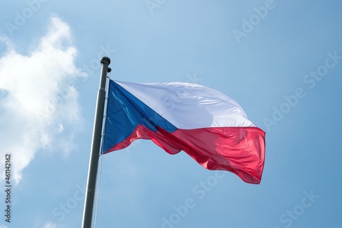 The national flag of the Czech Republic, flying under a blue sky.