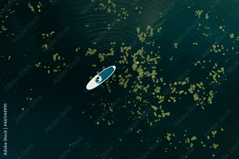 Aerial view of Man with stand up paddleboard in water Aerial view of Man with stand up paddleboard in water